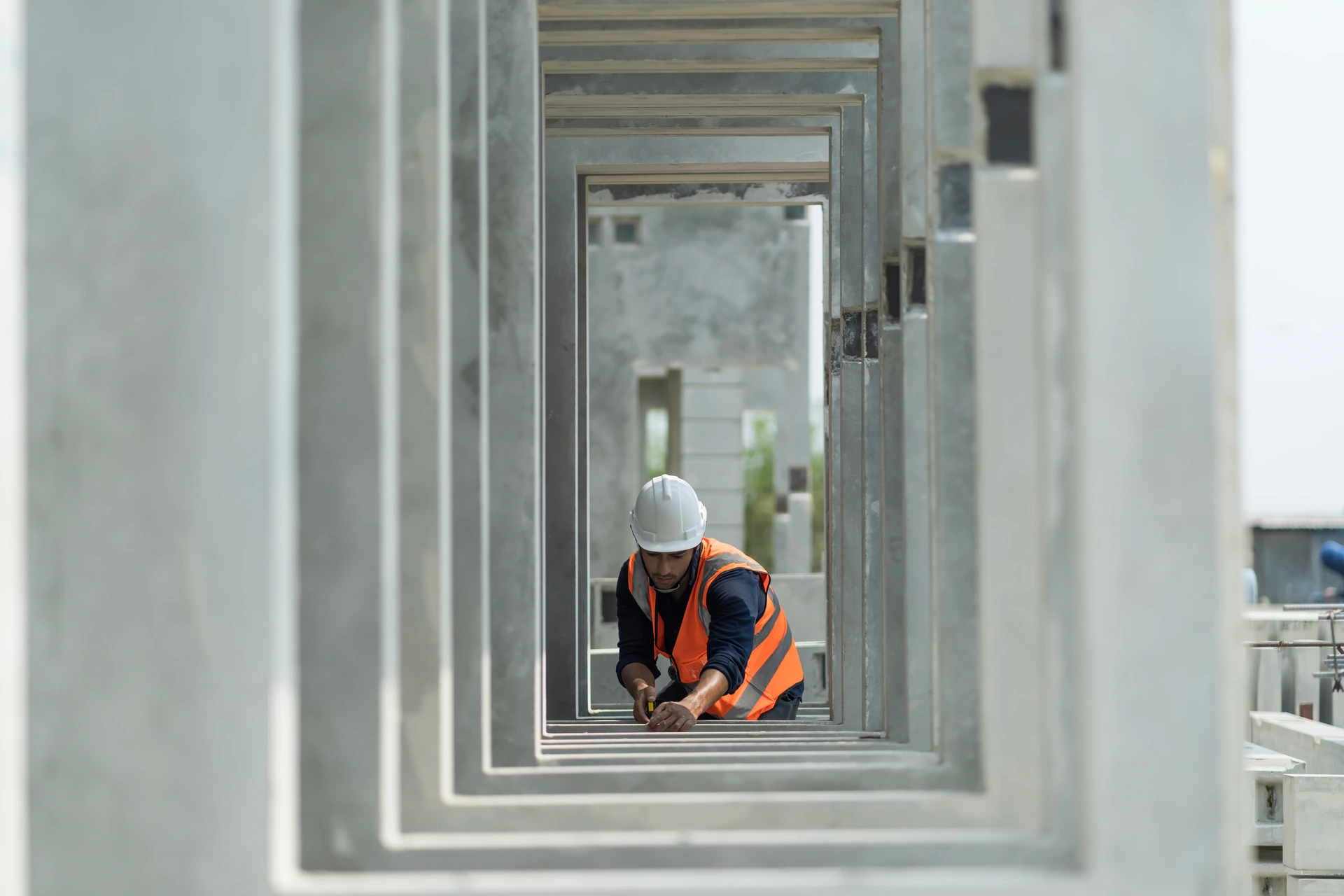 Byggarbetare i varselväst och hjälm arbetar i betongtunnel på byggarbetsplats.